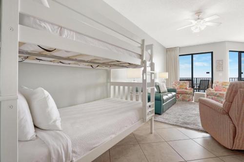 a bedroom with two bunk beds and a living room at Cozy 1BR/1BA Condo w/ Stunning Views in Orange Beach