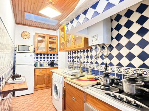 a kitchen with a sink and a stove top oven at Casa do Candeeiro in Óbidos