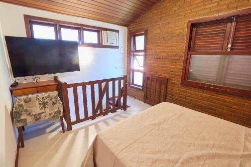 a bedroom with a bed and a flat screen tv at Acolhedor em Niteroi - Ideal para familias - Recanto in Niterói