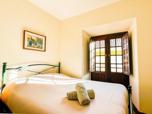 a bedroom with a bed and a window at Casa do Candeeiro in Óbidos