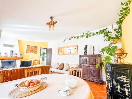 Una sala de estar con una mesa con un bol de fruta. en Casa do Candeeiro, en Óbidos