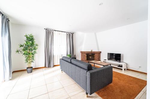 a living room with a couch and a tv at Flat Armada II - Apartamento T5 junto ao BragaParque in Braga