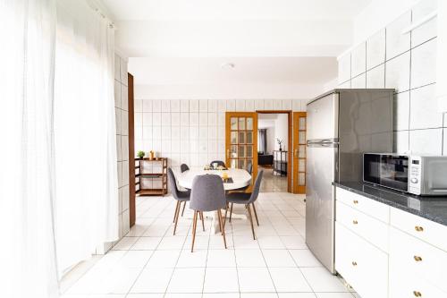 a kitchen with a table and chairs in a room at Flat Armada II - Apartamento T5 junto ao BragaParque in Braga