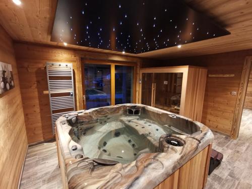 a jacuzzi tub in the middle of a room at Chalet 10 pers sauna & SPA La tanière des Vosges in La Bresse