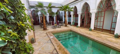 een binnenzwembad in een gebouw met bomen bij Riad Ramzi in Marrakesh