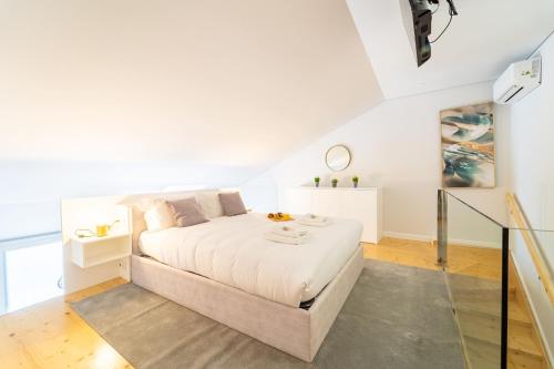 - une chambre blanche avec un lit et un escalier dans l'établissement Charming Studio Álvares Fagundes by House and People, à Viana do Castelo