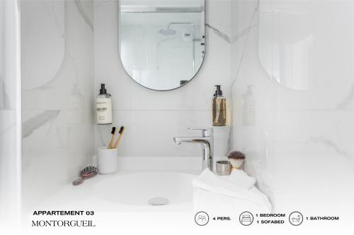 a white bathroom with a sink and a mirror at Beauquartier - Montorgueil in Paris
