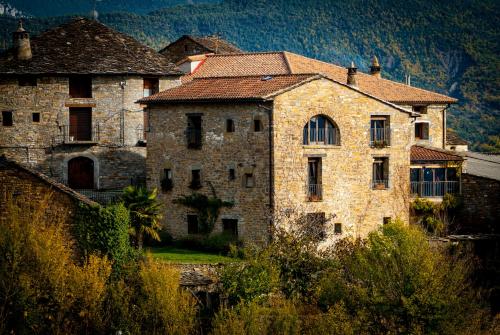 an old stone building with a roof at O Chardinet d'a Formiga in Aínsa