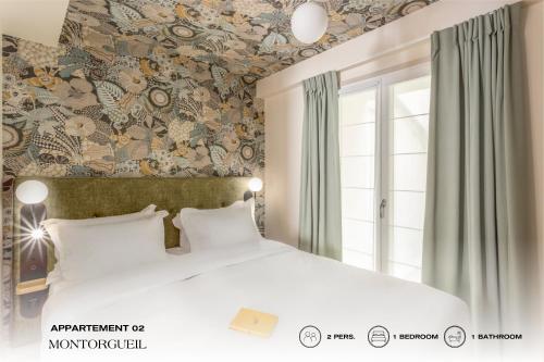a bedroom with a large bed with a floral wallpaper at Beauquartier - Montorgueil in Paris