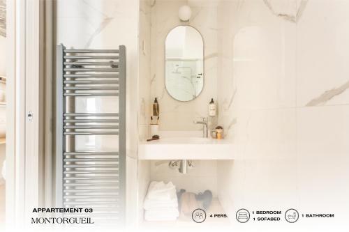a white bathroom with a sink and a mirror at Beauquartier - Montorgueil in Paris