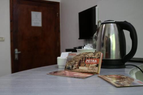 a tea kettle and a book on a table at Value Place in Wadi Musa