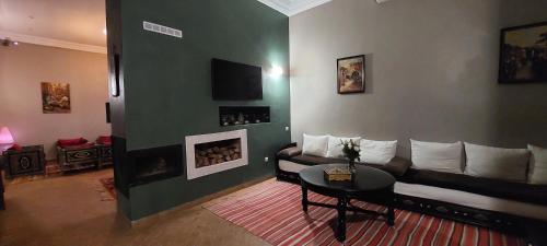 a living room with a couch and a fireplace at Riad Ramzi in Marrakech