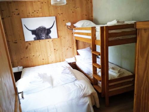 a room with two bunk beds and a picture of a cow at Chalet de Xonrupt / Vue splendide sur les montagnes in Xonrupt-Longemer