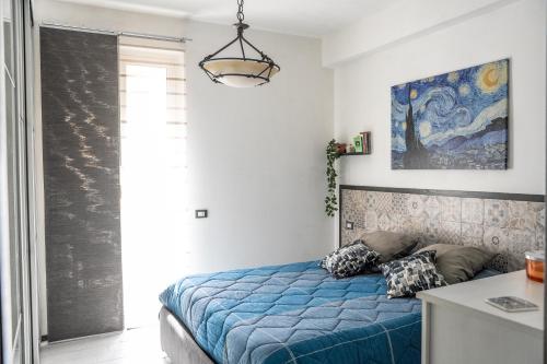 um quarto com uma cama com um edredão azul em Centre View em Altofonte