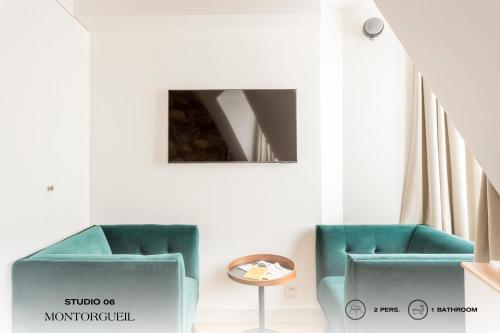 a room with two green chairs and a table at Beauquartier - Montorgueil in Paris
