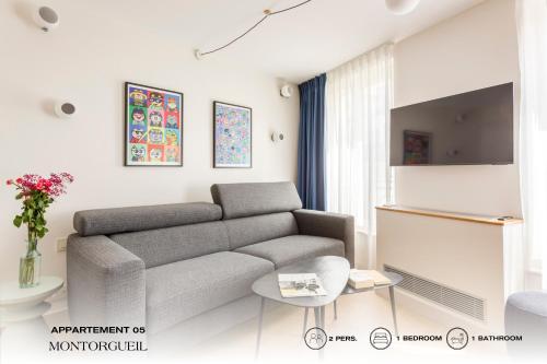 a living room with a couch and a table at Beauquartier - Montorgueil in Paris