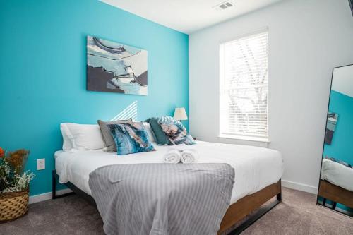 a blue bedroom with a large bed with blue walls at Brand-new Parkview with Balcony in Old Fourth Ward 542Blvd203 in Atlanta