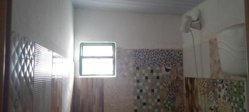 a bathroom with a window and a shower with a shower curtain at GRUTA da Praia 2 in Saquarema