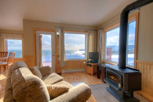 a living room with a couch and a stove at Domaine Frais Air in La Malbaie