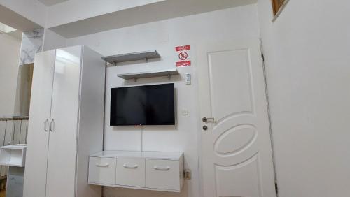 a white room with a tv and a door at Petreski Apartments 1 in Ohrid