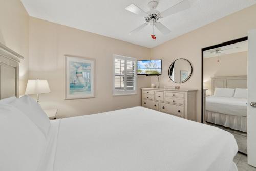 a white bedroom with a bed and a ceiling fan at Stunning Views, 3BD/2BA w/ Private Balcony in Orange Beach