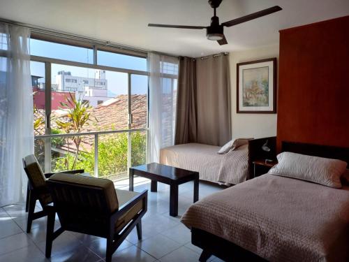 Habitación de hotel con cama y ventana en Posada Galeria Alberto Sedas en Huatusco de Chicuellar
