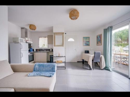 un salon avec un canapé et une table et une cuisine dans l'établissement Maison Caroline Arkea Arena, à Bouliac