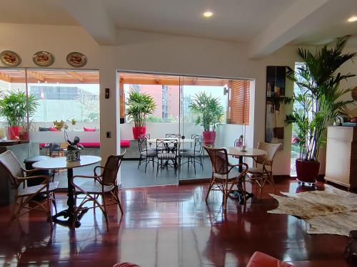 a dining room with tables and chairs and plants at Ana Frank Boutique Hotel in Lima