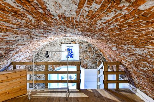 a room with a bunk bed and a ladder in a brick wall at RUSTICO ALLE MURA Love & Bike in Toirano