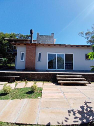 a white house with a staircase in front of it at Chalé em Torres Recanto Estelar in Torres