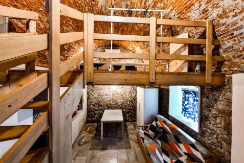 a room with wooden bunk beds and a brick wall at RUSTICO ALLE MURA Love & Bike in Toirano