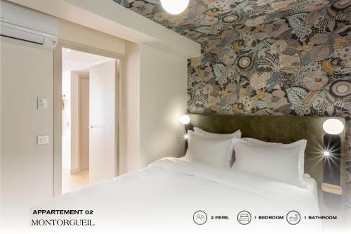 a bedroom with a white bed with a floral wallpaper at Beauquartier - Montorgueil in Paris