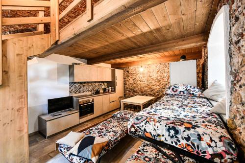 een kleine slaapkamer met een bed en een keuken bij RUSTICO ALLE MURA Love & Bike in Toirano