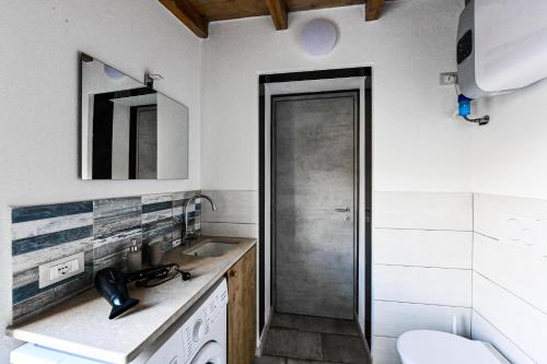 a white bathroom with a sink and a toilet at RUSTICO ALLE MURA Love & Bike in Toirano