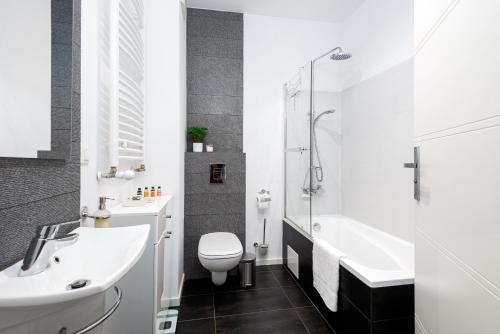 łazienka z umywalką, toaletą i wanną w obiekcie Apartment Kozielska z pięknym ogrodem i tarasem w mieście Gliwice