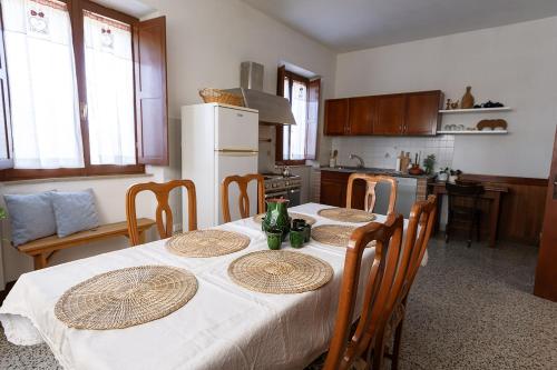 a kitchen with a table with chairs and a refrigerator at ZEM casolare in Petriolo