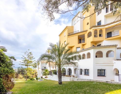een gebouw met een palmboom ervoor bij Apartment in Cabopino in Marbella