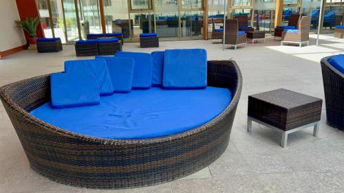 a wicker chair with blue cushions in a shopping mall at LRH Calama, an Ascend Collection Hotel in Calama