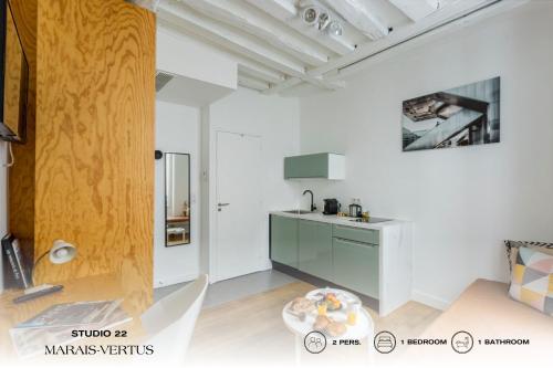 a kitchen with a sink and a table in a room at Beauquartier - Marais, Vertus in Paris