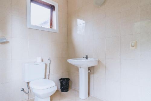 La salle de bains blanche est pourvue de toilettes et d'un lavabo. dans l'établissement Casa a 5 minutos da Praia Rasa, em Búzios, à São Vicente