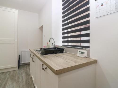 a kitchen with a sink and a window at RockStar Cottage in Macduff