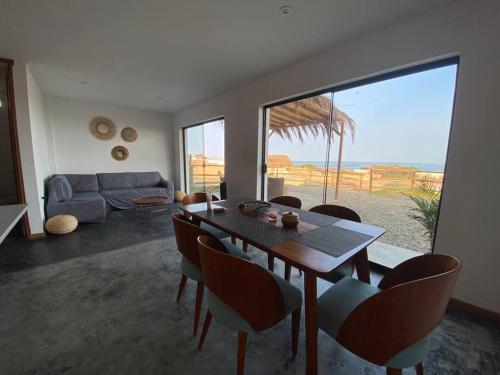 sala de estar con mesa, sillas y sofá en Casa de Playa con Piscina Privada, en Los Órganos