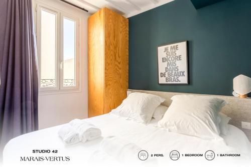 a bedroom with a bed with white sheets and a window at Beauquartier - Marais, Vertus in Paris