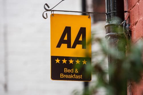 een bord voor een bed and breakfast in een gebouw bij Darwin's Townhouse in Shrewsbury