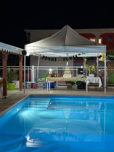 a blue swimming pool in front of a tent at Les Villas de Boisvin in Le Moule