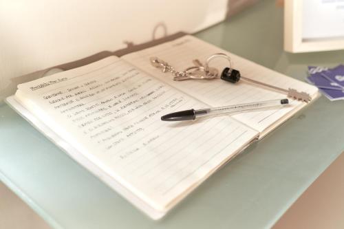 a pen and a piece of paper with a keychain at Casa nostra aeroporto e mare in Fiumicino