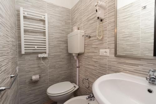 a bathroom with a toilet and a sink and a mirror at Hotel Guidi in Mestre