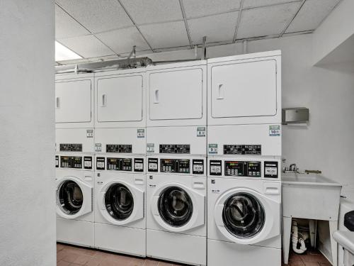 a row of white washing machines in a laundry room at Mantell Plaza Apartments in Miami Beach