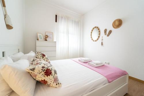 a white bedroom with a large white bed with pillows at Casino and Beach Apartment by House and People in Póvoa de Varzim