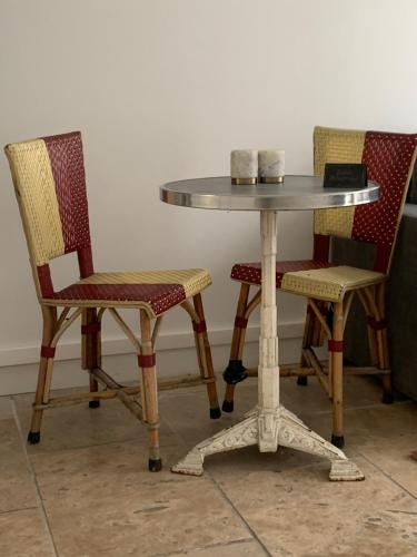 2 Stühle und ein Tisch mit einem Tisch und 2 Stühlen in der Unterkunft La parisienne in Le Raincy